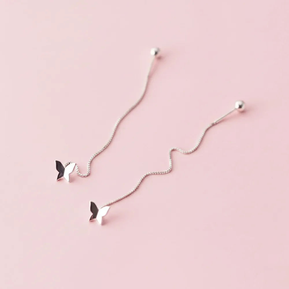 Silver fjärilsformade dangle örhängen med kedja och kulformade stift från aimeé tasseldesign