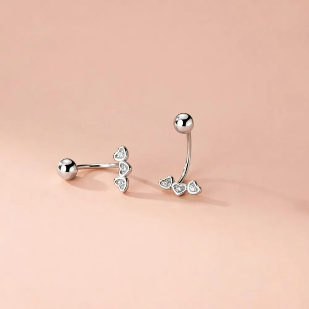 Silver belly button ring med krokdesign och tre hjärtformade hängen med klara kristaller