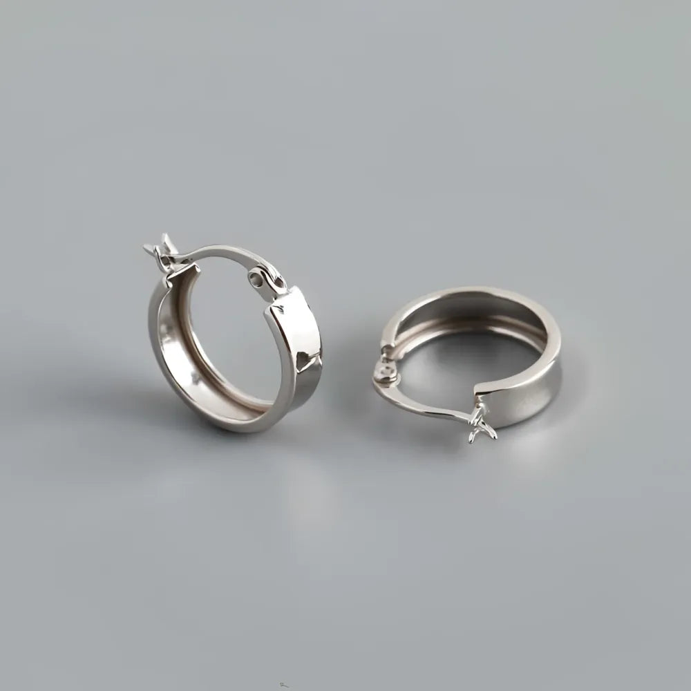 Fiona silver hoops i olika storlekar med minimalistisk design och små stjärnformade lås i silver