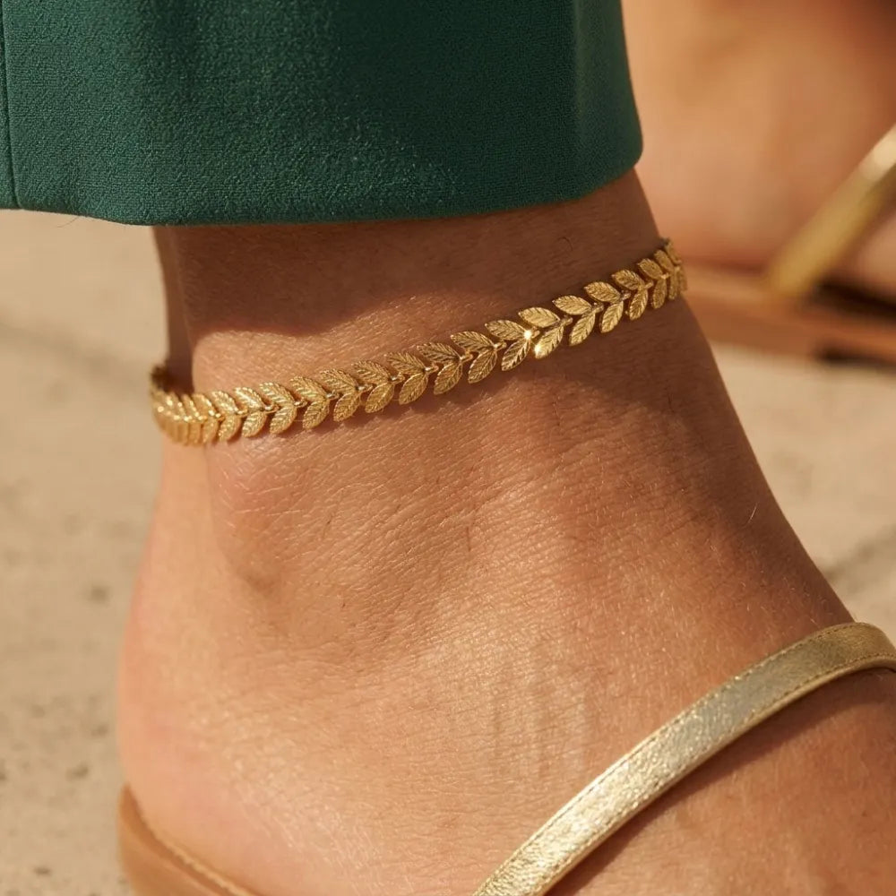Madeline fotlänk med sammanlänkade guldtonade löv mönstrad anklets runt ankeln