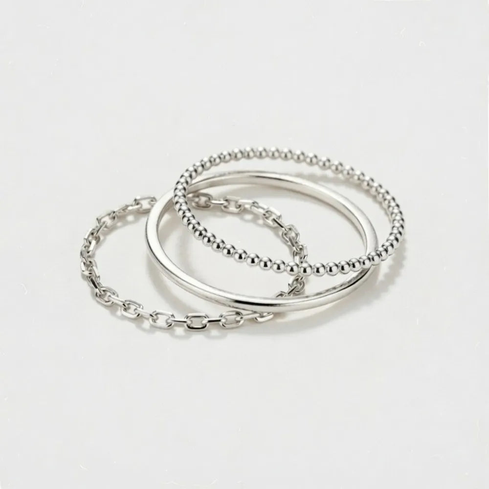 Slim triple trepack med trendiga silverfärgade ringar i slät, pärlstruktur och kedjemönster designs