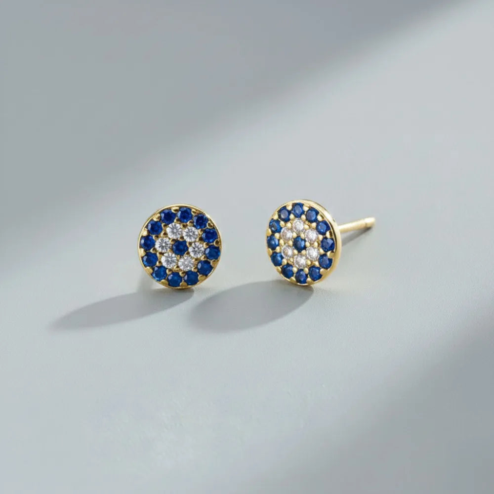 Guldtonade runda studs med blå och klara stenar i koncentriska rader från blue eyes