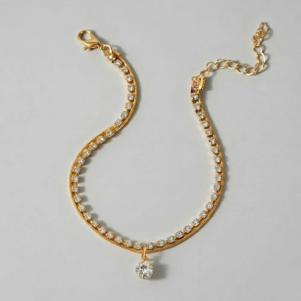 Celia fotlänk med dubbla guldfärgade kedjor och gnistrande kristaller med större hängande sten