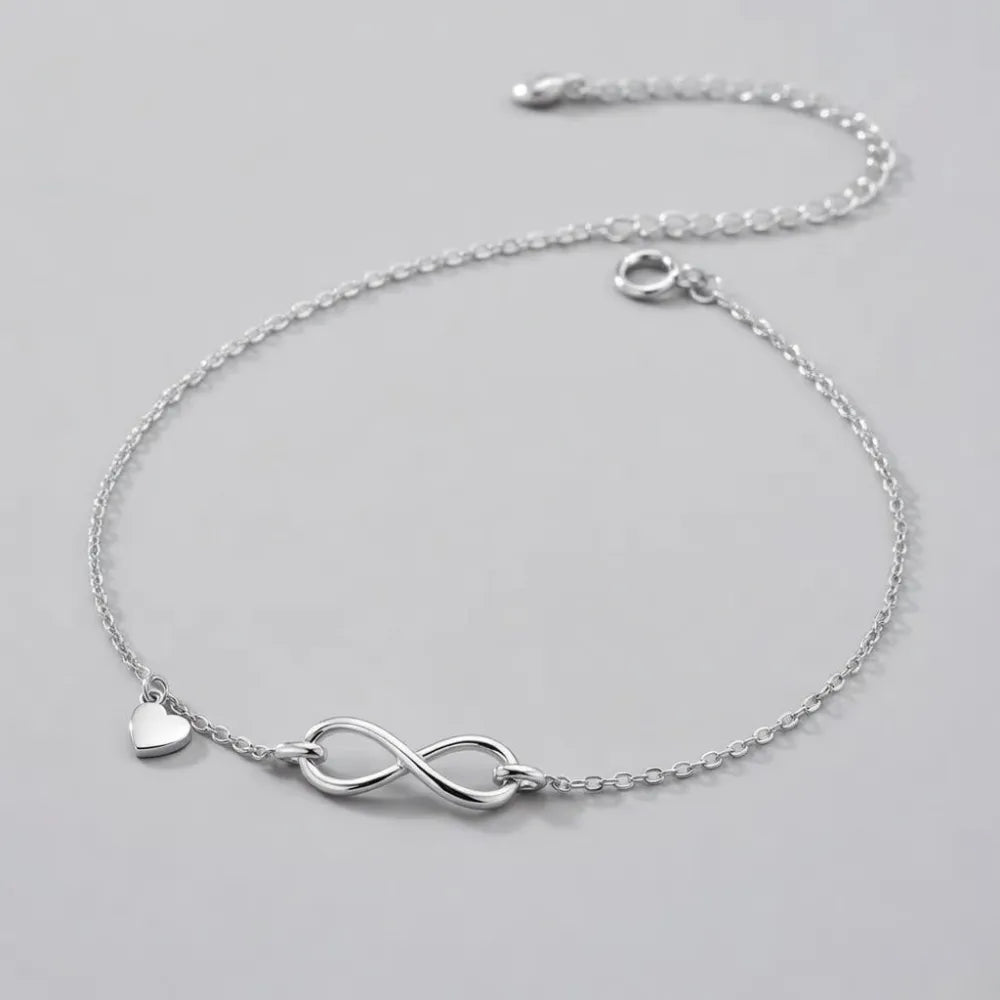 Silverfotlänk eternity med enkel infinitysymbol och liten hjärtsmycke i silver med fin kedja och säker låsning