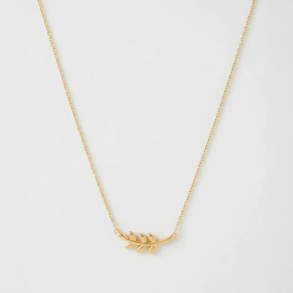 Ett delikat guldtonat halsband med lövformad hängsmycke och tunn kedja evergreen modell