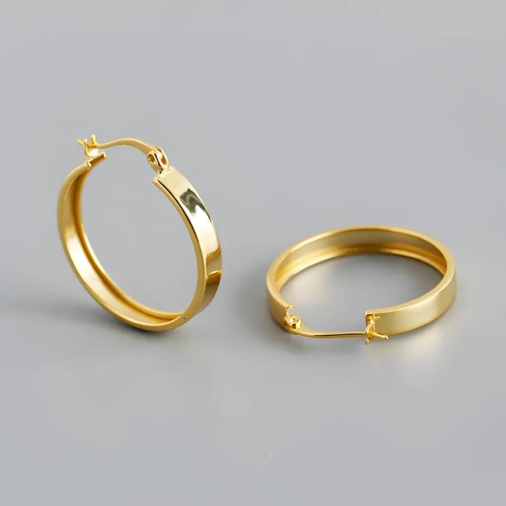 Fiona hoops i olika storlekar i guld med minimalistisk design och polerad metallyta