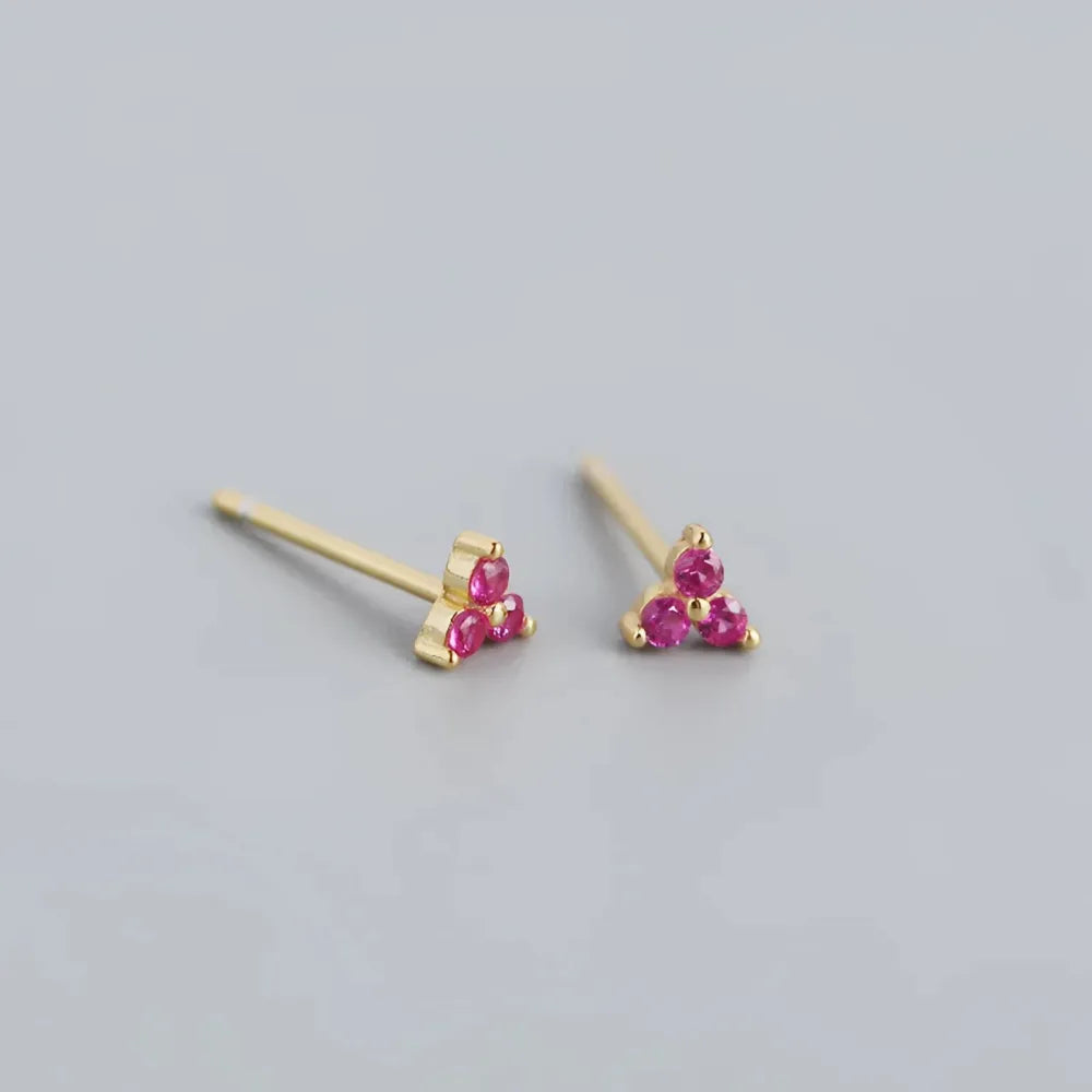 Franka små studs med tre rosa ädelstenar i triangulär form och delikat guldfinish