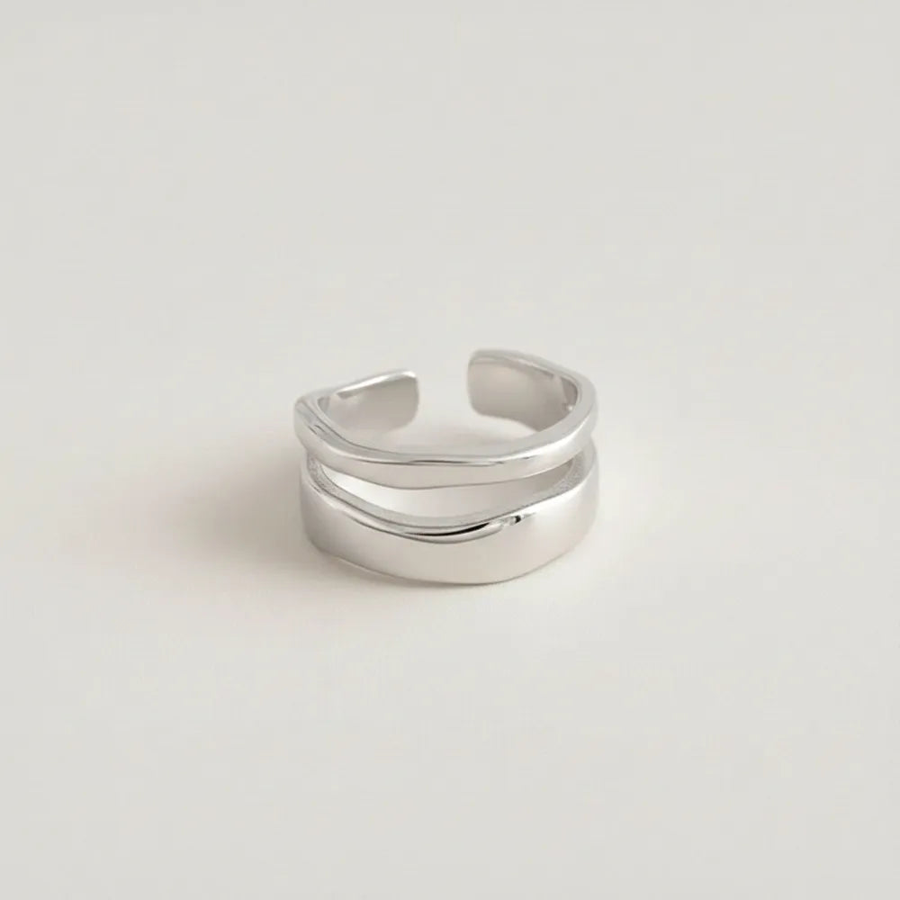En silverfärgad justerbar ring med dubbla banor och öppen tå i modern och stilren design