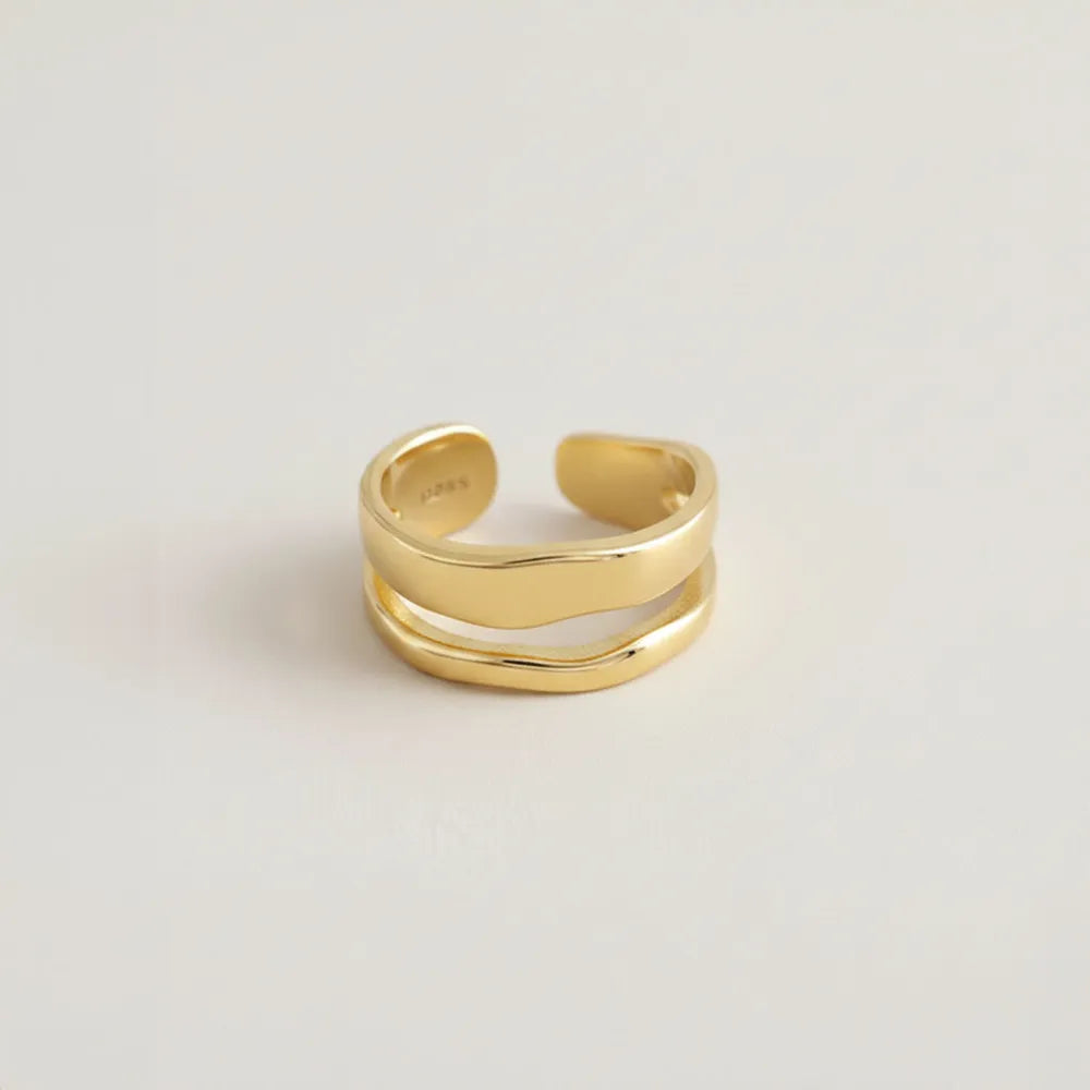 Justerbar ring freja i guldfärgat minimalistiskt design med två överlappande släta band