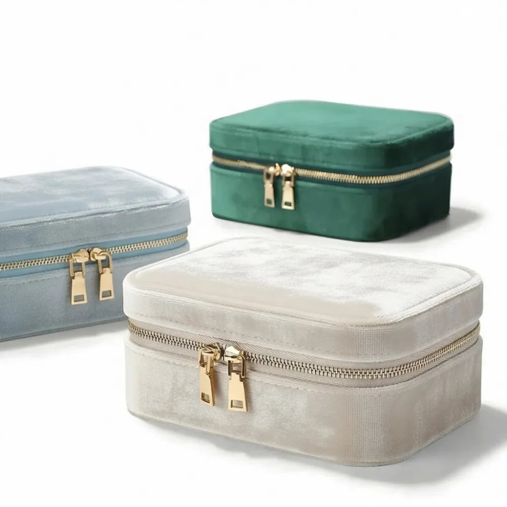 Elegant sammetssmyckesskrin i mjuk beige med guldfärgad blixtlås och dragflikar glittrasken