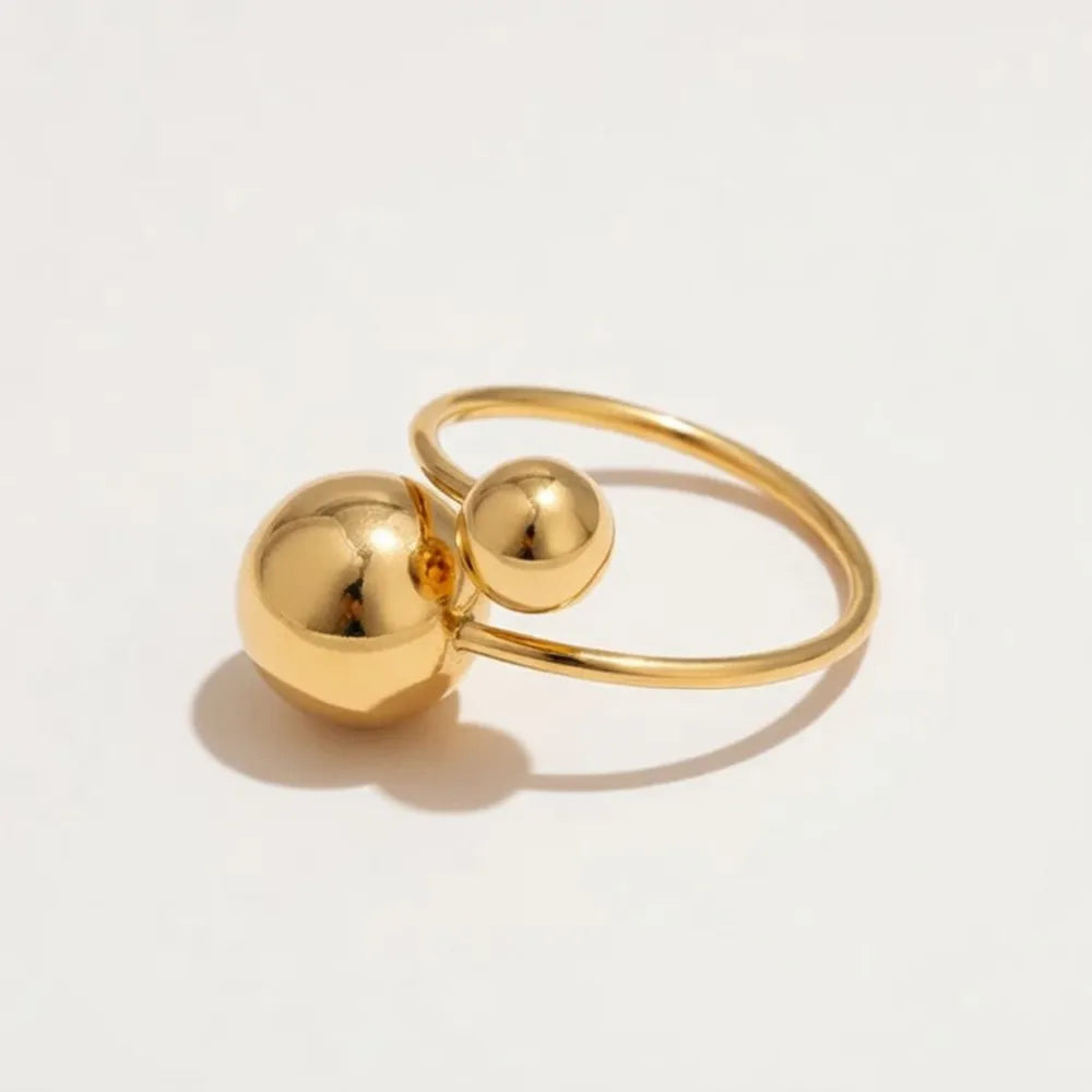 Goldtonad justerbar omlottring med två polerade sfäriska glober för en minimalistisk stil