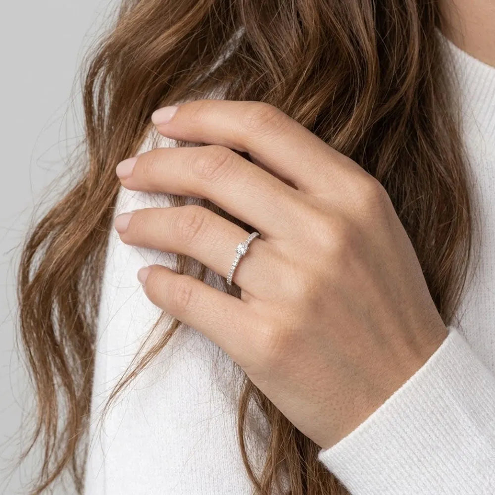 Gloria ring med liten sten i silver med central diamant och mindre stenar på fingret