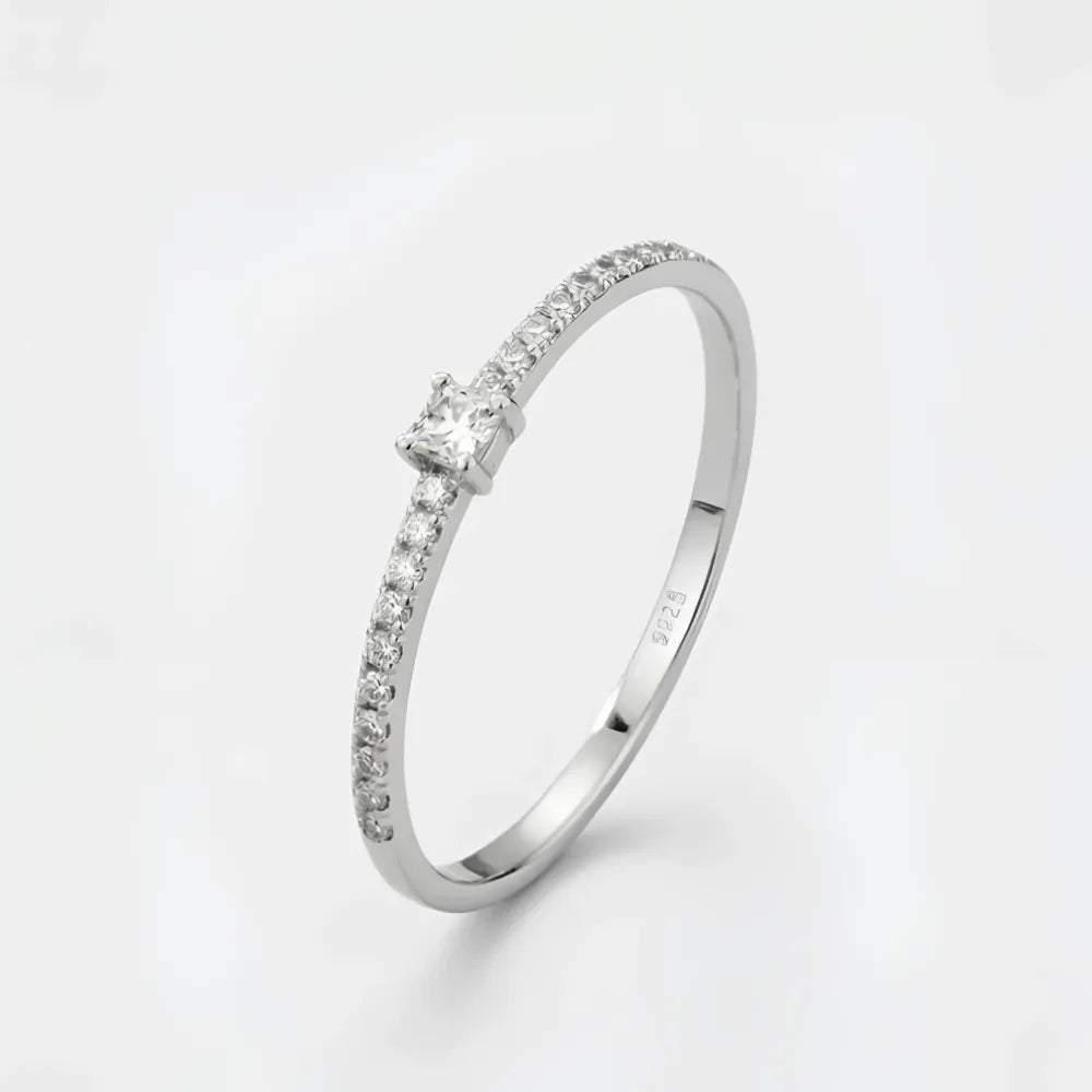 Gloria ring med liten sten en silverbandring med prinsesslipad diamant och mindre pavé diamanter på sidan