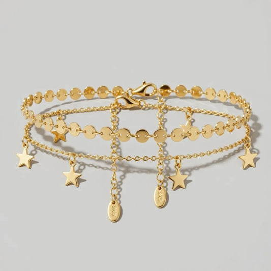 Grethe fotlänk med dubbla guldfärgade kedjor och hängande stjärnformade berlocker i minimalistisk design