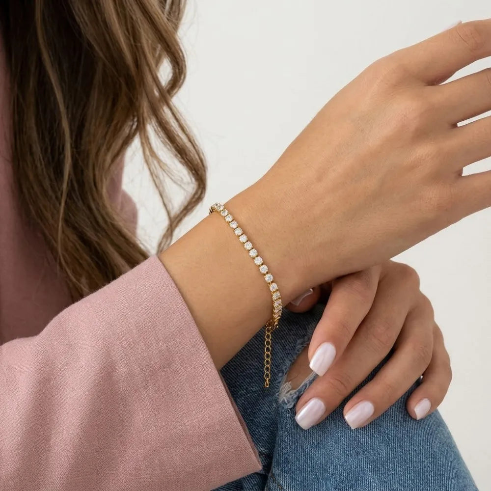 Inez tennisarmband i guldfärg med en rad glittrande klara stenar för elegant användning