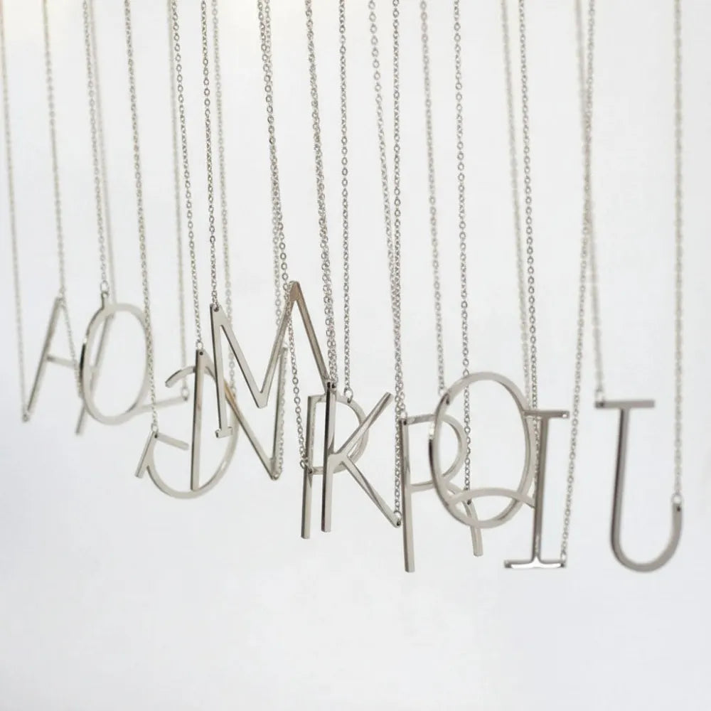 Silver juno halsband med stor bokstav i minimalistisk, tunn metallhängande från en fin kedja