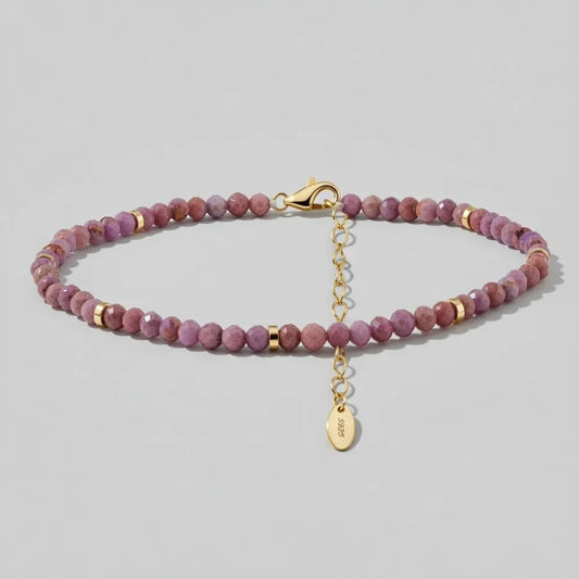 Lavendel fotlänk med lila stenar och guldtonade detaljer i en tunn pärlad design med liten oval tagg