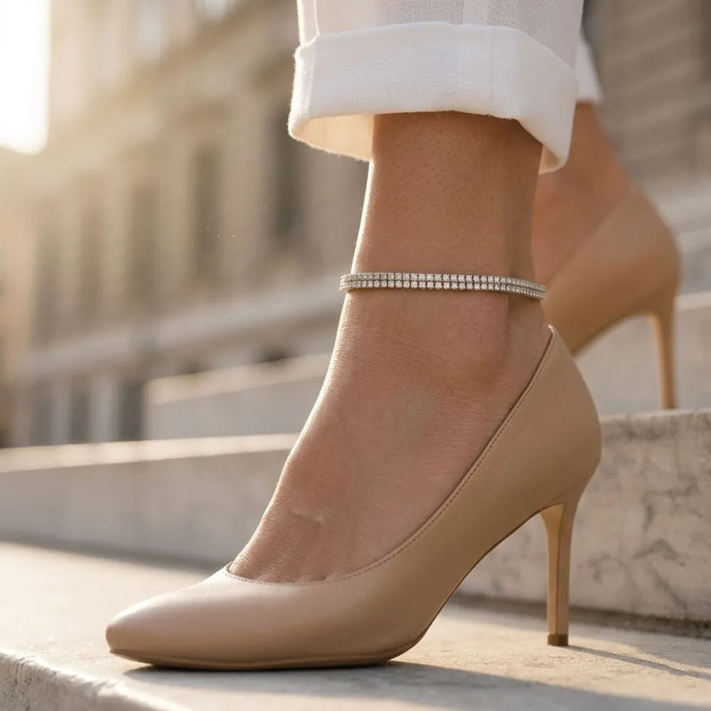 Beige läderpump med hög klack och glittrande fotlänk med bred kedja och stenar