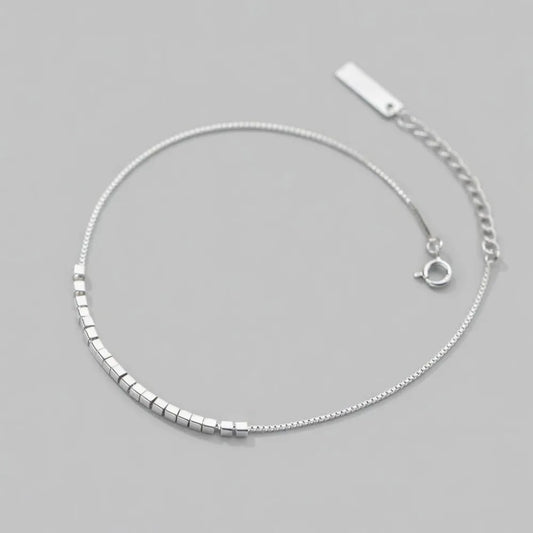 Linn fotlänk i silver med små polerade fyrkantiga pärlor och justerbart spänne med rektangulär tagg