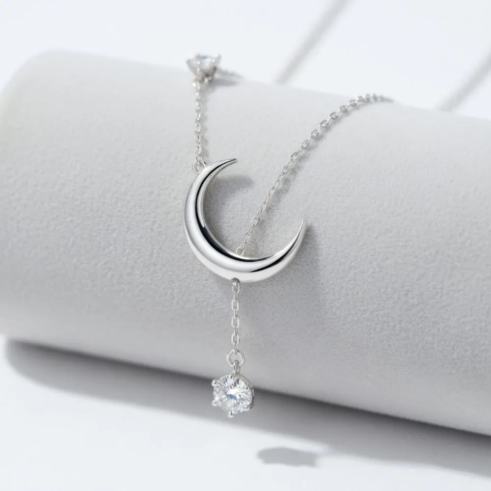 Silver halvmånehalsband med tunn kedja och hängande kristallpendel i smycket lune
