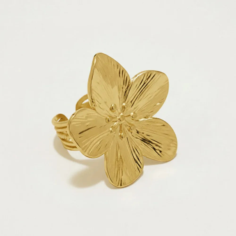 Guldfärgad justerbar ring magnolia med stor blomma och texturerade kronblad på vriden ringband