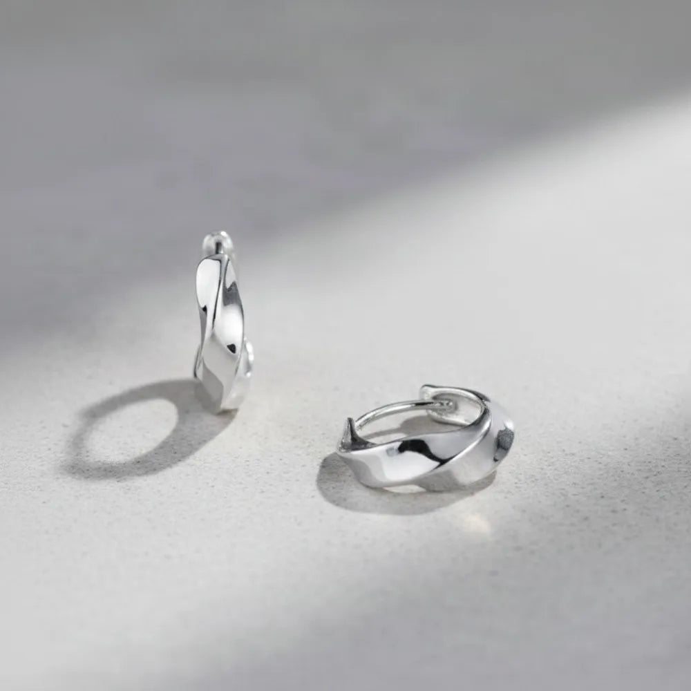 Silver huggie örhängen med tvinnad modern design i metall wind kollektion