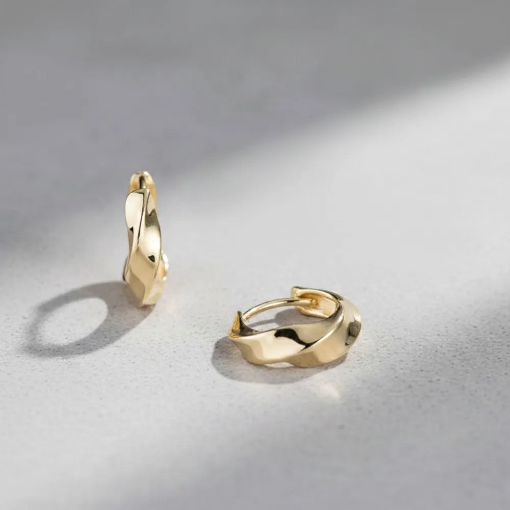 Goldtonade huggies med tvinnad metallisk design för en modern och elegant stil