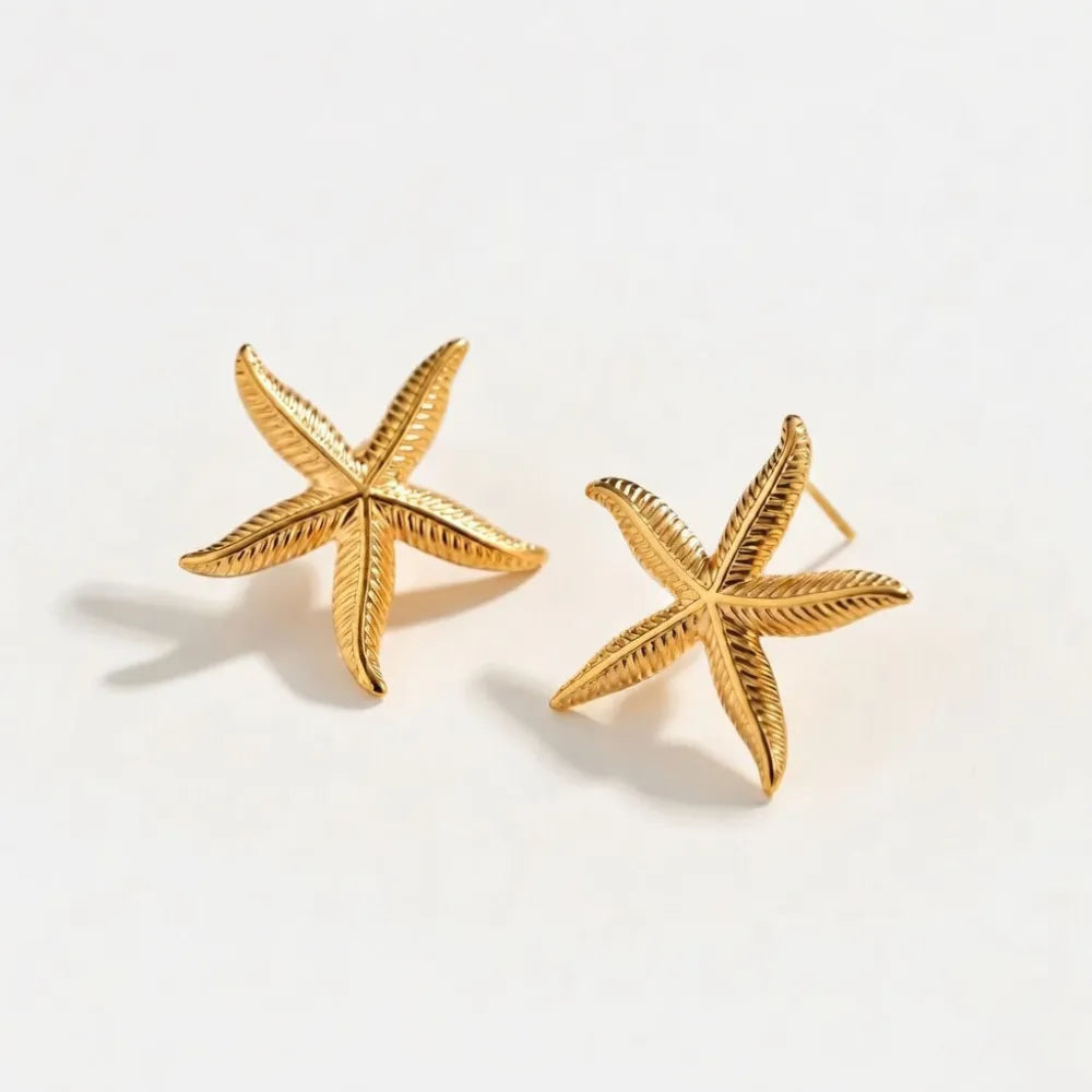 Guldörhängen nerina med sjöstjärna form och texturerade räfflade armar i metall