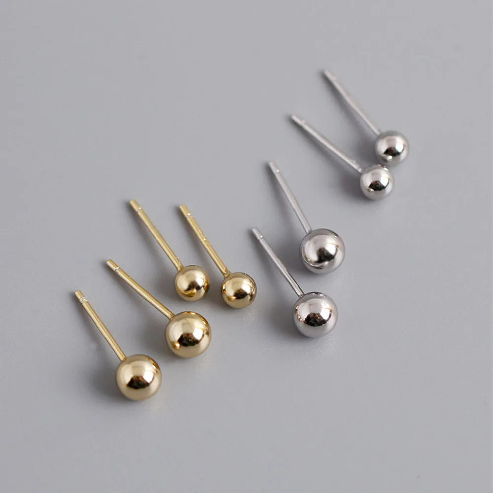Polly små runda studs i minimalistisk design med guldfärgade och silverfärgade metallkulor på tunna stift