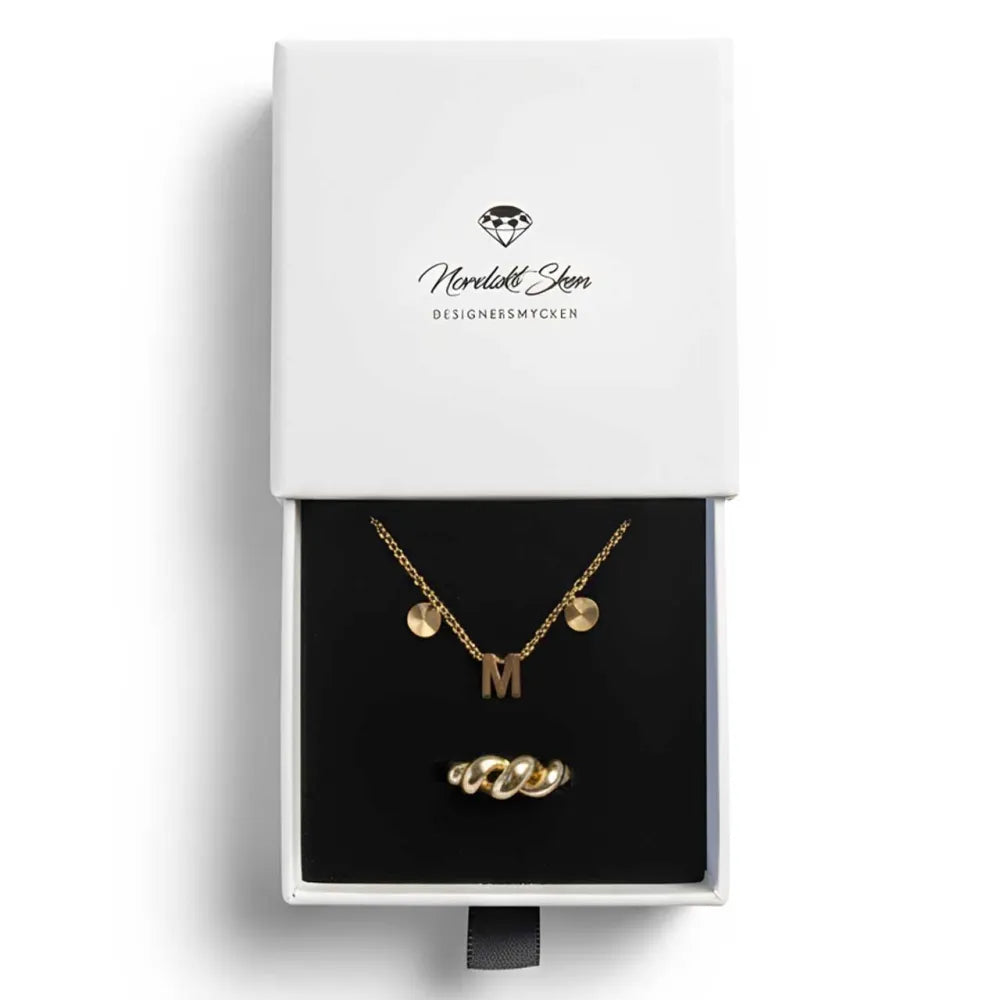 Guldhalsband med initial m-pendant och två runda berlocker samt matchande vriden ring i presentask från moreløkken designersmcken