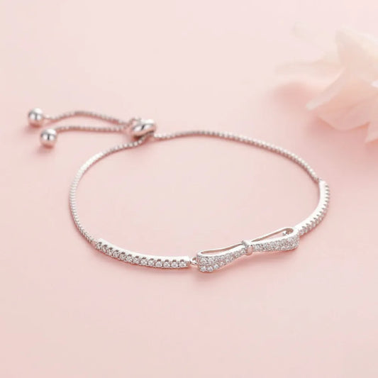 Silver rosett armband med glittrande klara kristaller längs kedjan och central rosettdetalj
