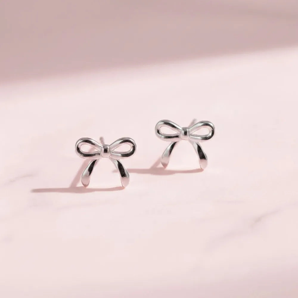 Silver rosette studs med liten minimalistisk rosett av silver i enkel design
