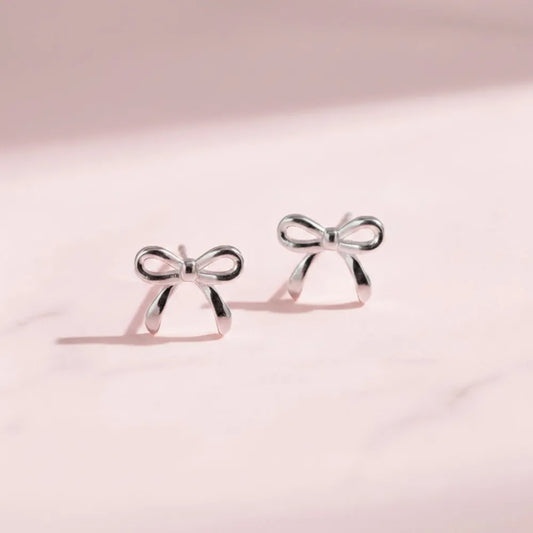 Silver rosette studs med liten minimalistisk rosett av silver i enkel design