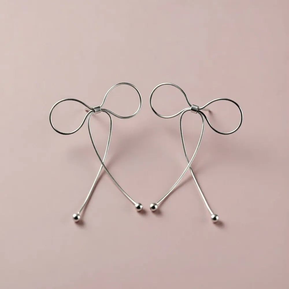 Rosie örhängen i silver med rosettmotiv och minimalistisk design med hängande kulor