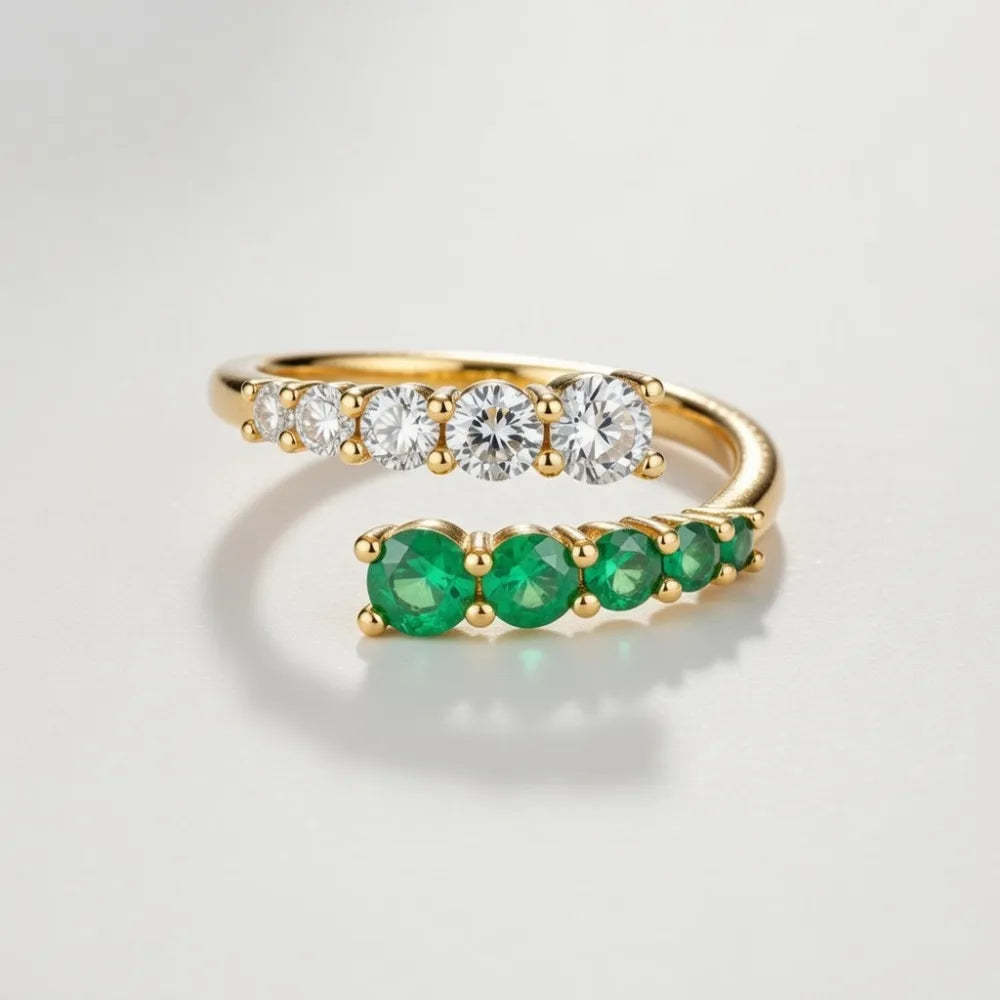 Guld ring med justerbar omlottring design med fem vita diamanter på ena sidan och fem gröna smaragder på andra sidan