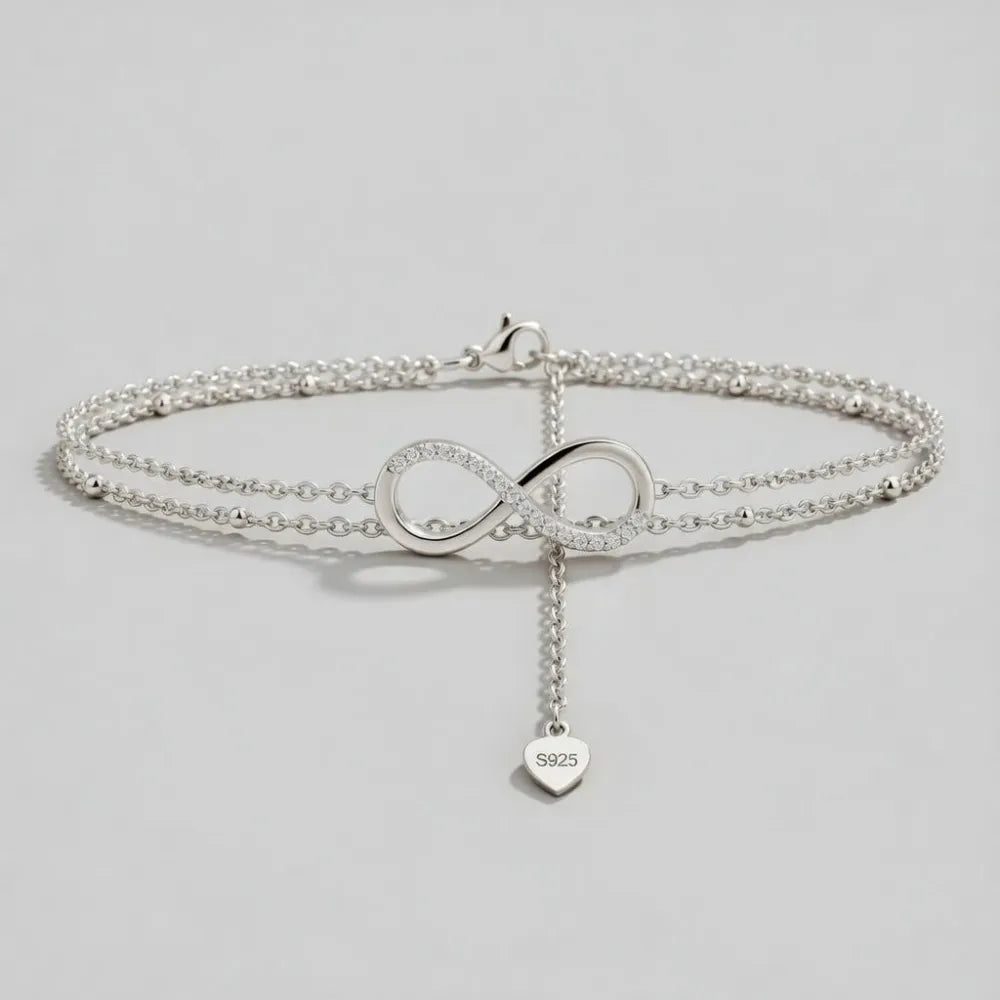 Silver infinity symbol anklet with pave-set crystals and s925 engraved heart charm in timeless fotlänk med dubbla kedjor