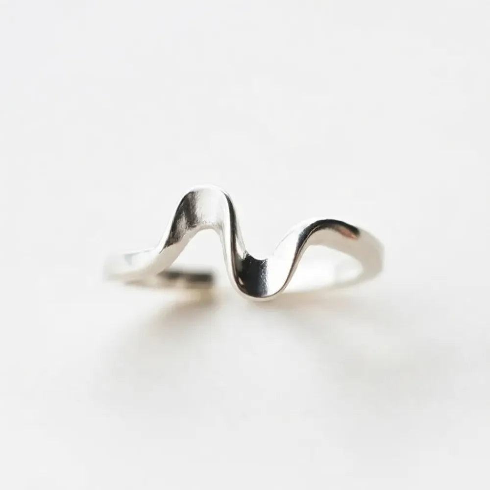 A sleek silver adjustable ring with a wavy design named wavy water justerbar nätt ring med vågig form