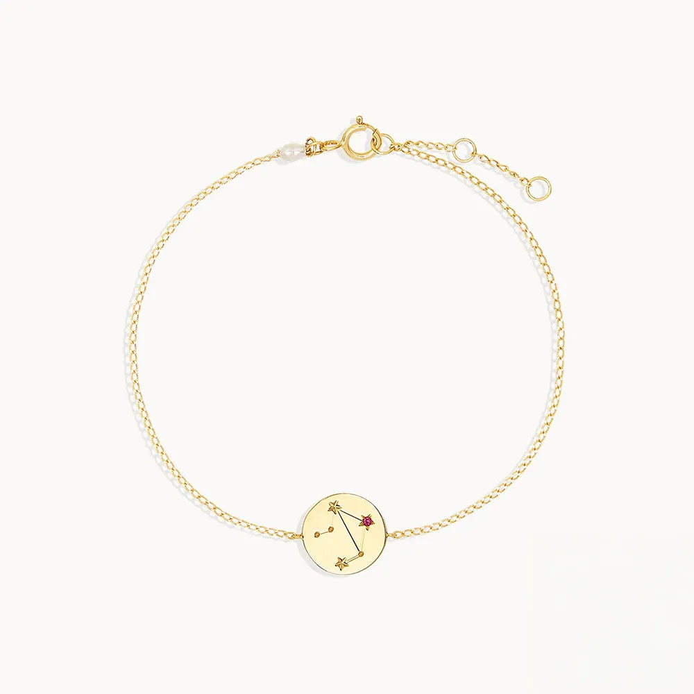 Zodiac sign armband i guldfärg med konstellationsberlock och röd ädelsten inbyggd