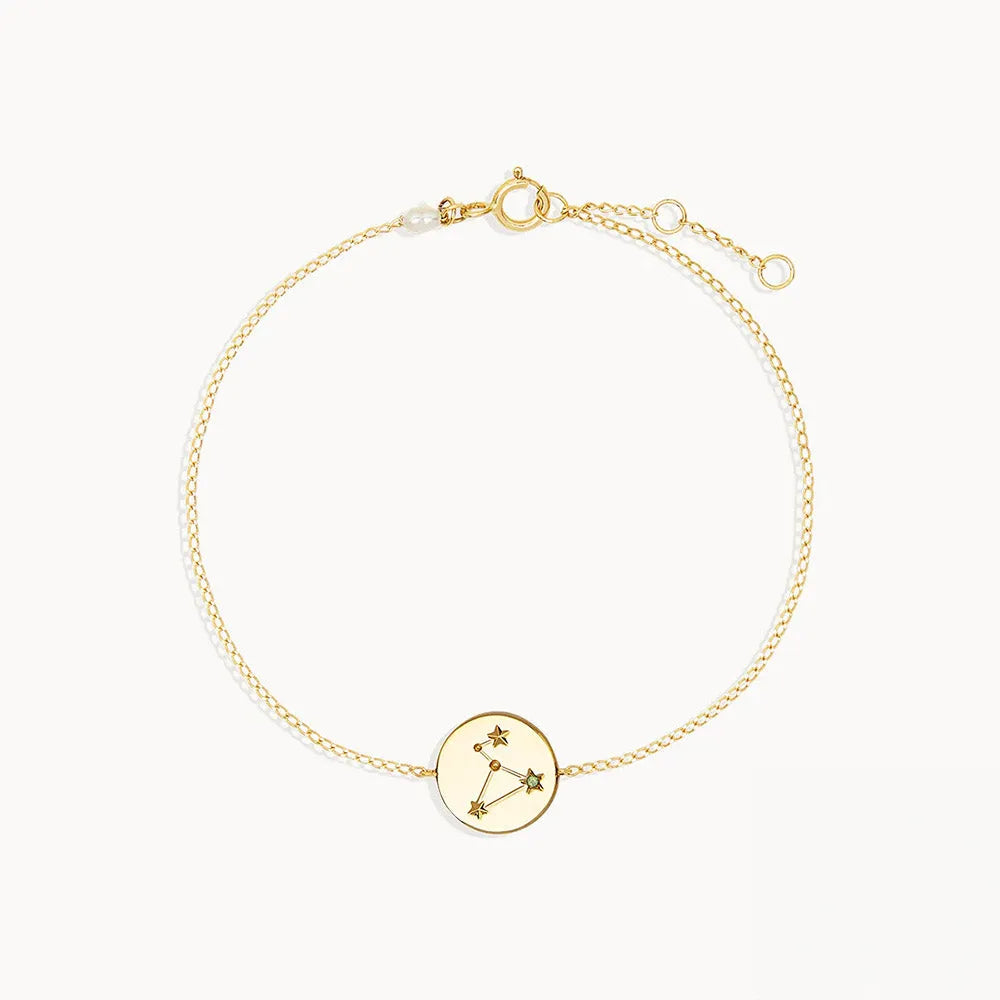Zodiac sign armband i guldton med stjärnteckenmotiv och cirkulärt hänge på fin kedja