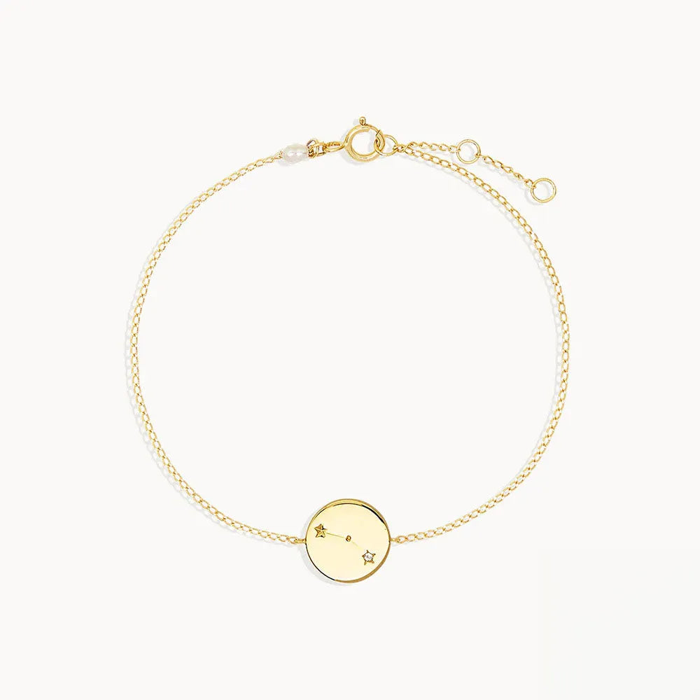 Zodiac sign armband i guldfärgad ton med delikat kedja och cirkelformat diskcharm graverad med stjärntecken