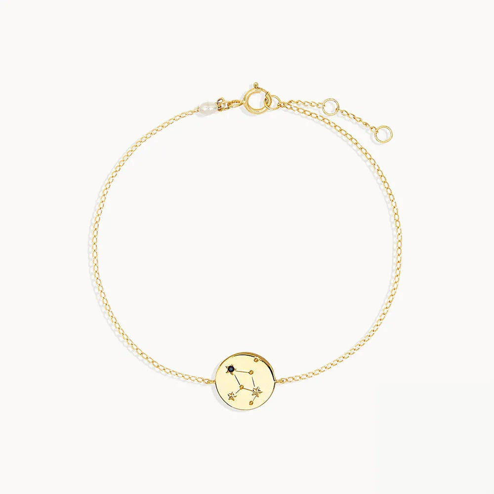 Zodiac sign armband med stjärntecken i guldfärgat metall med cirkulär berlock prydd med stjärnor och stenar